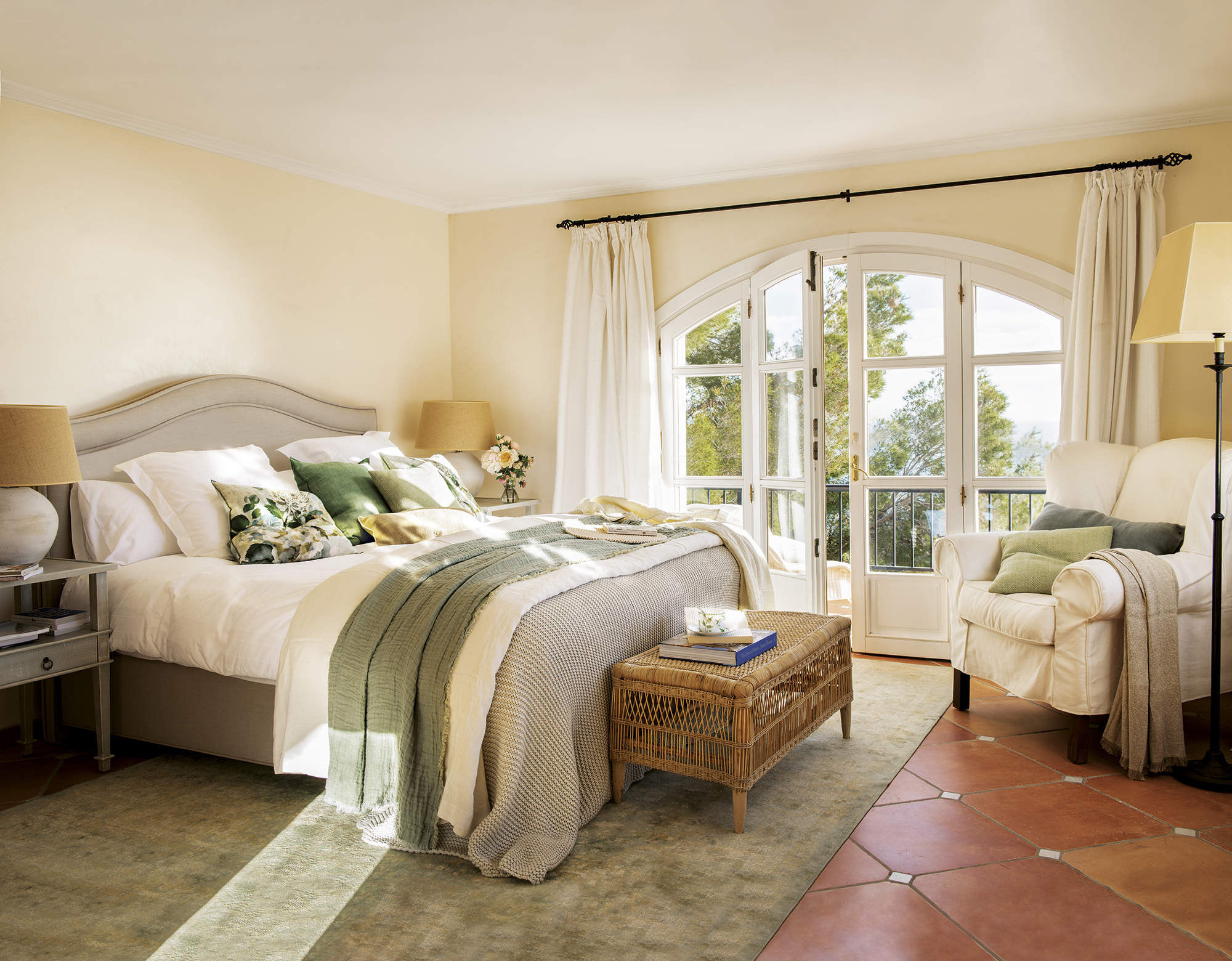 dormitorio con ropa de cama verde y blanca, alfombra verde, butaca tapizada blanca